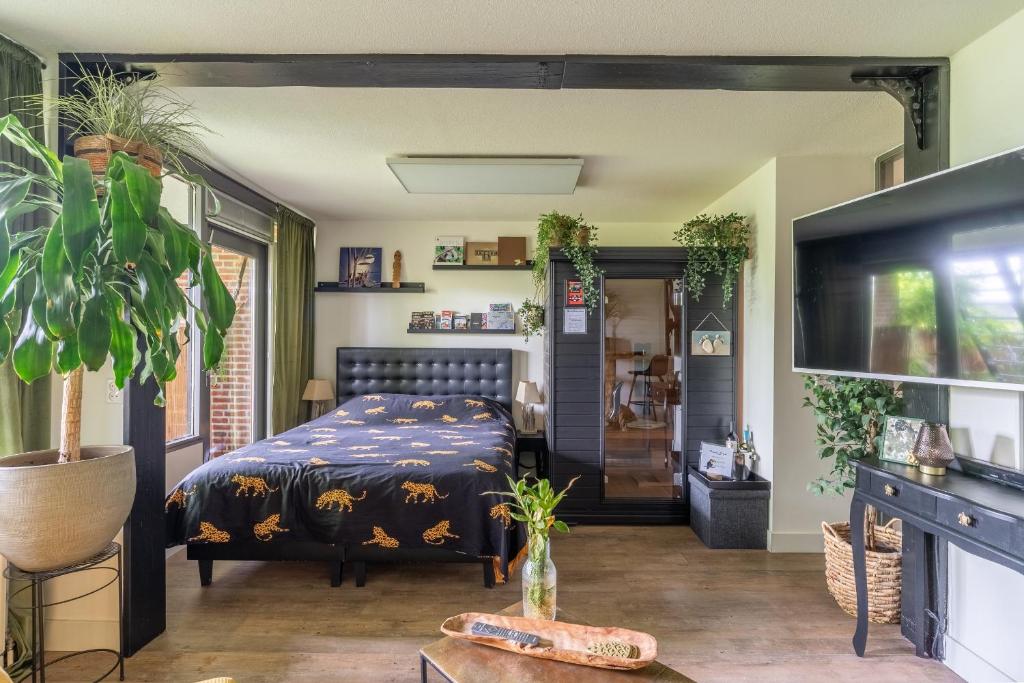 1 dormitorio con 1 cama y TV en Jungle Stay in a Hidden Paradise, en Zwijndrecht