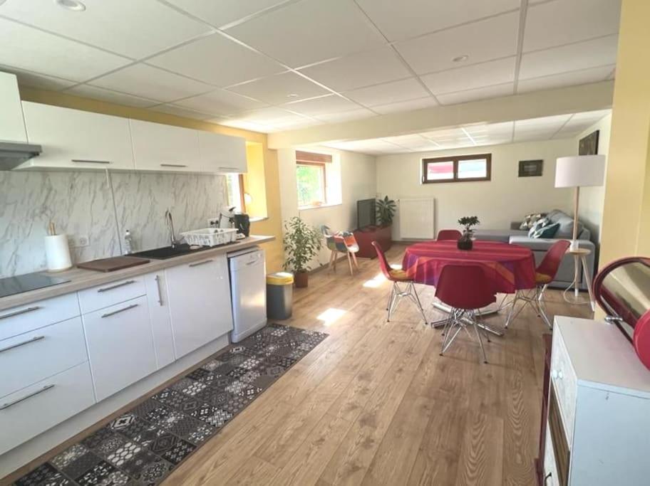 une cuisine et une salle à manger avec une table et des chaises rouges dans l'établissement Au petit bonheur, à Horbourg-Wihr