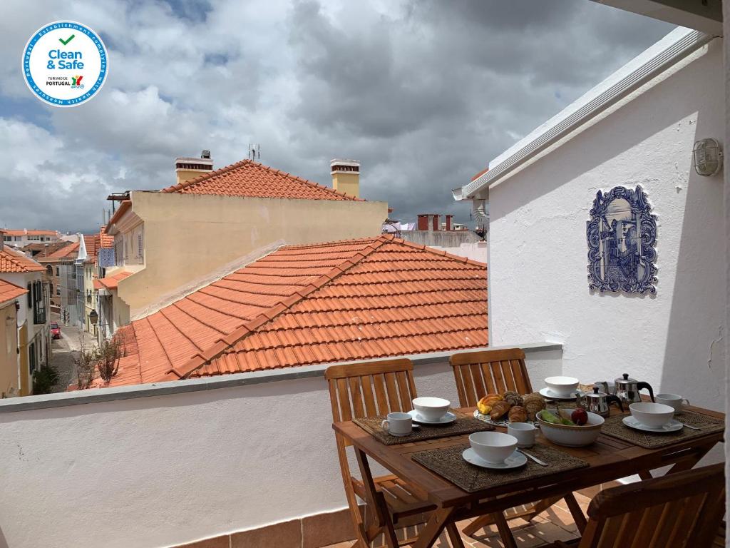 a table with bowls of food on a balcony at Charming old town in Cascais