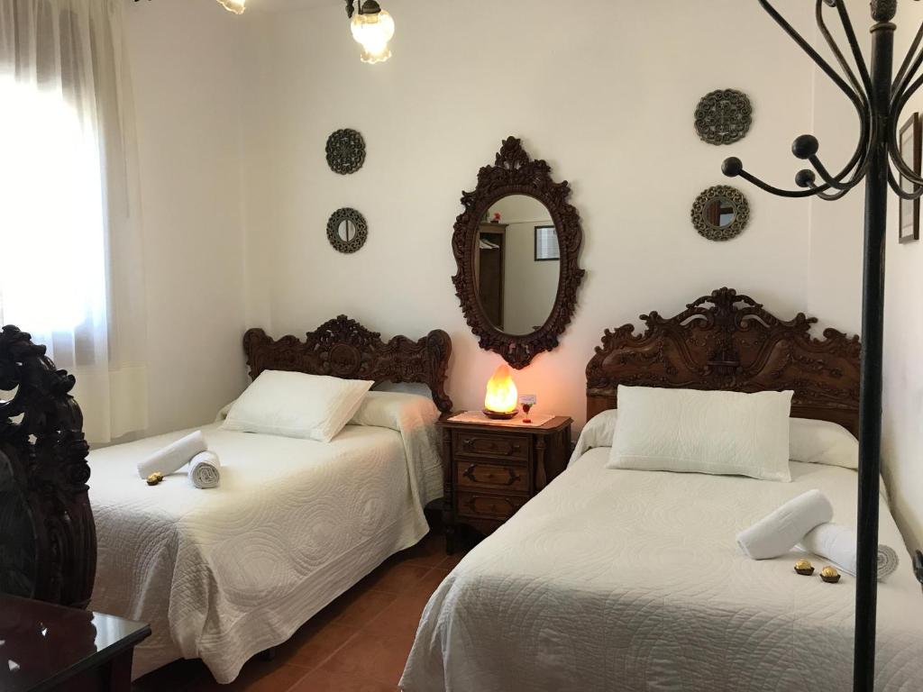 a bedroom with two beds and a mirror at Casa Pedro in Roquetas de Mar