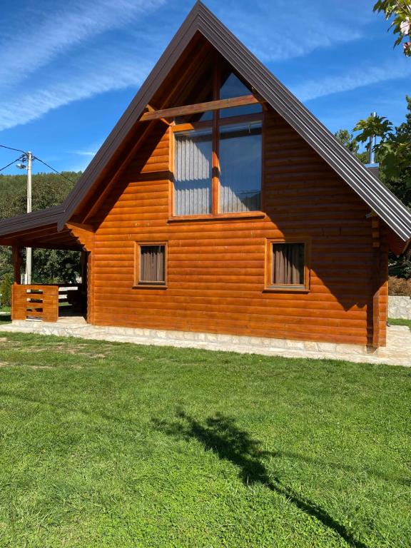 a wooden house with a large window in a yard at Vikendica Pavle in Trebinje