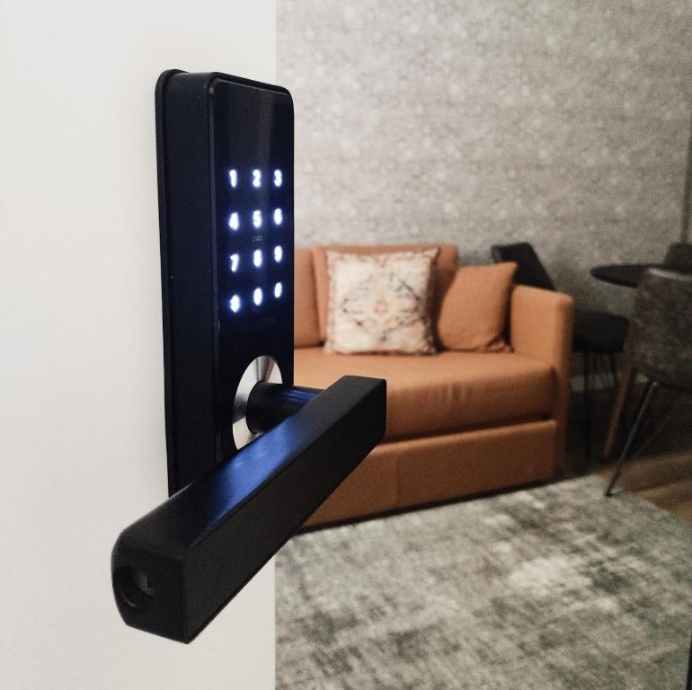 a wall mounted remote control in a living room with a couch at The Bastion Elvas Apartments in Elvas