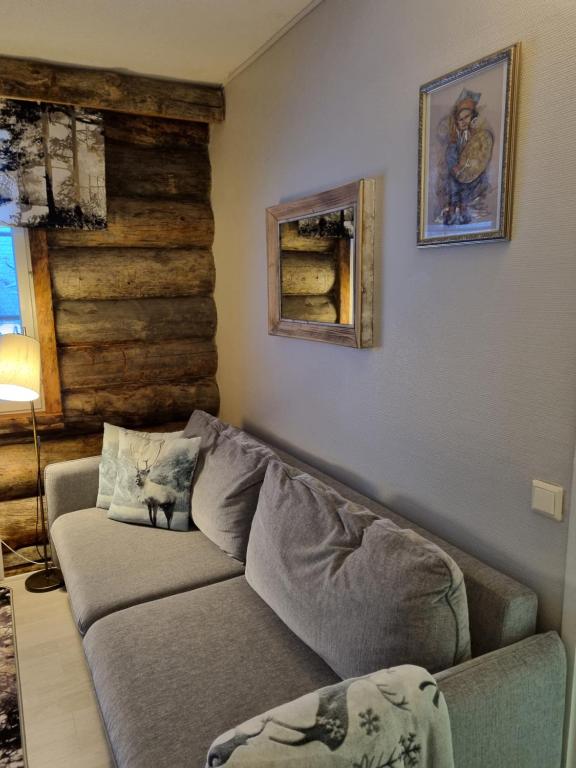 a living room with a couch and a wall at Polaris Homes Huippu in Syöte