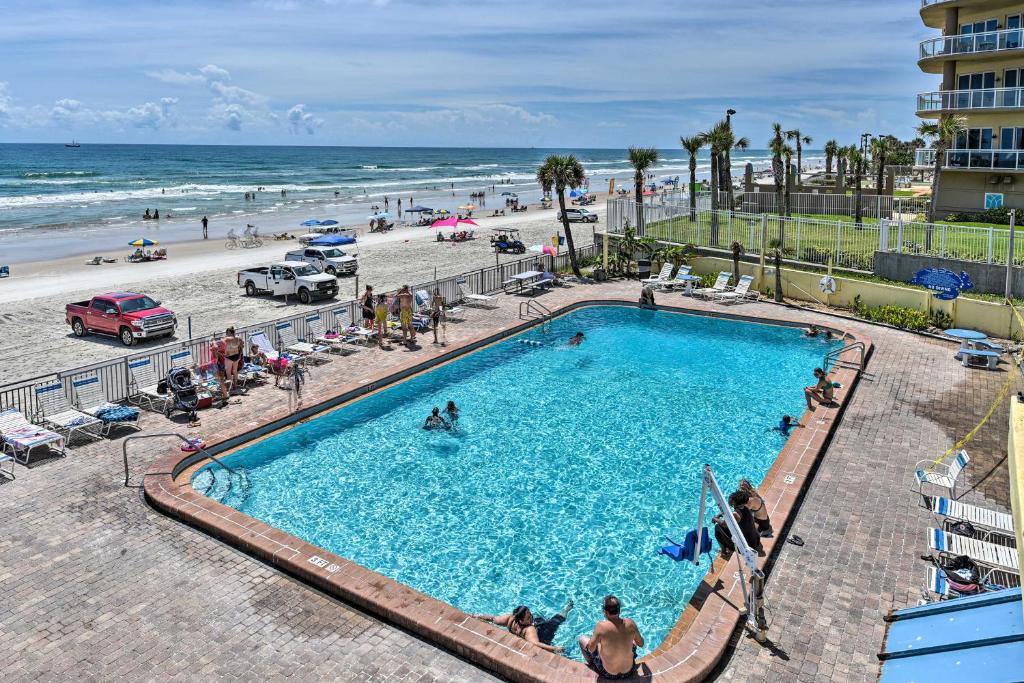 a swimming pool next to a beach with people in it at Beachfront Daytona Studio, Close to Parks! in Daytona Beach
