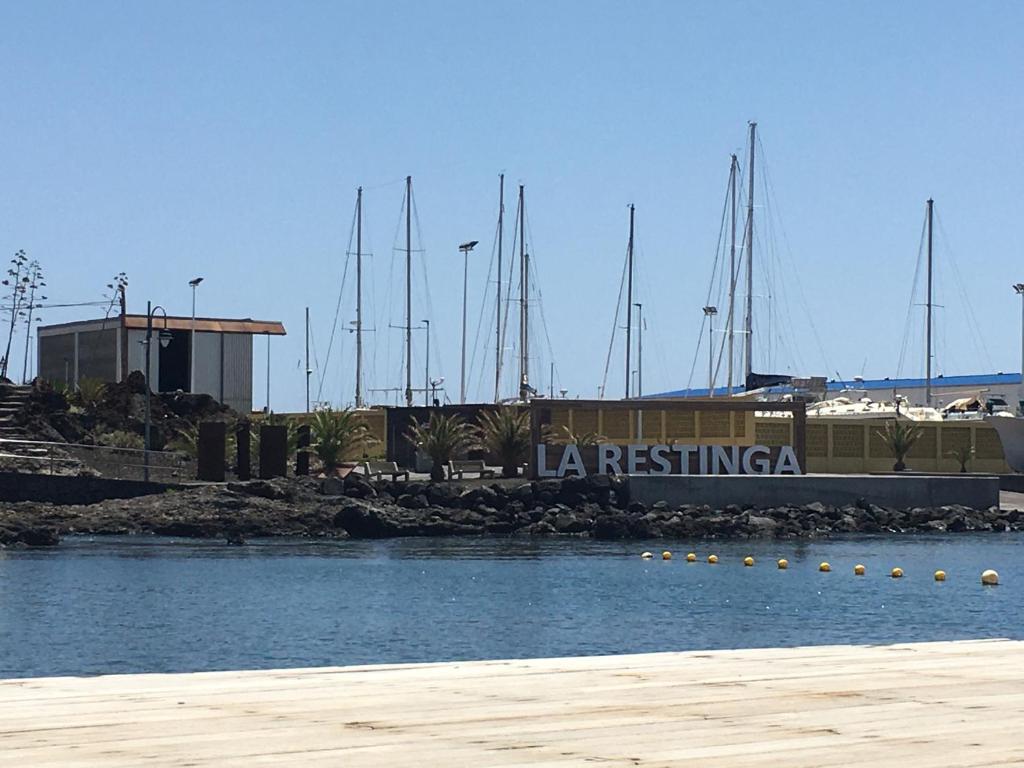 a marina with boats in the water and a building at Apto Tagoro, La Restinga in La Restinga