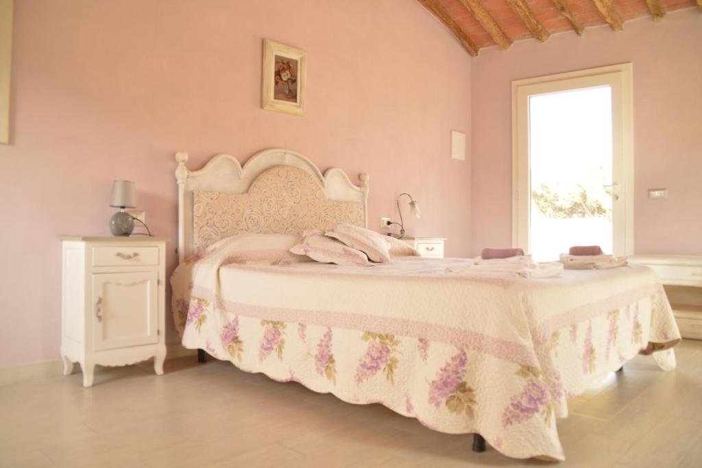 a pink bedroom with a bed and a window at Hotel Gli Acquerelli in Portoferraio
