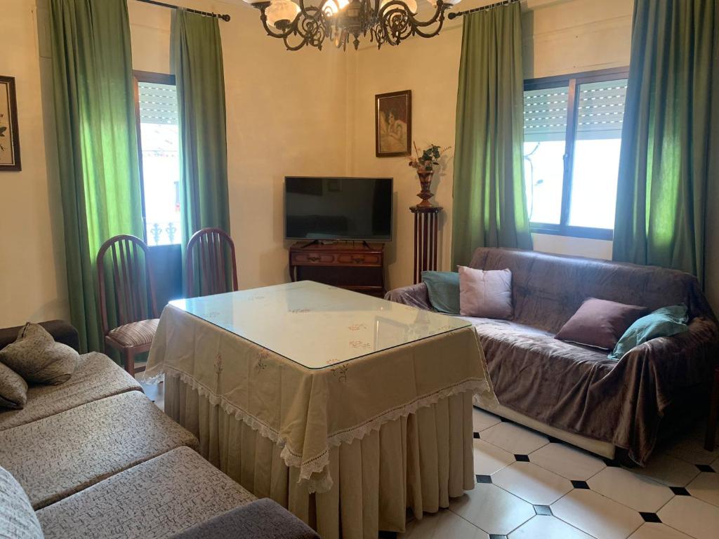 ein Wohnzimmer mit einem Sofa und einem Tisch in der Unterkunft Casa La Fábrica in Algodonales