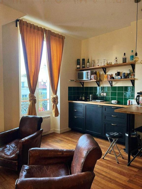 a kitchen with a couch and chairs and a table at Villa Ermitage-Appartement Paris - Buttes Chaumont in Paris