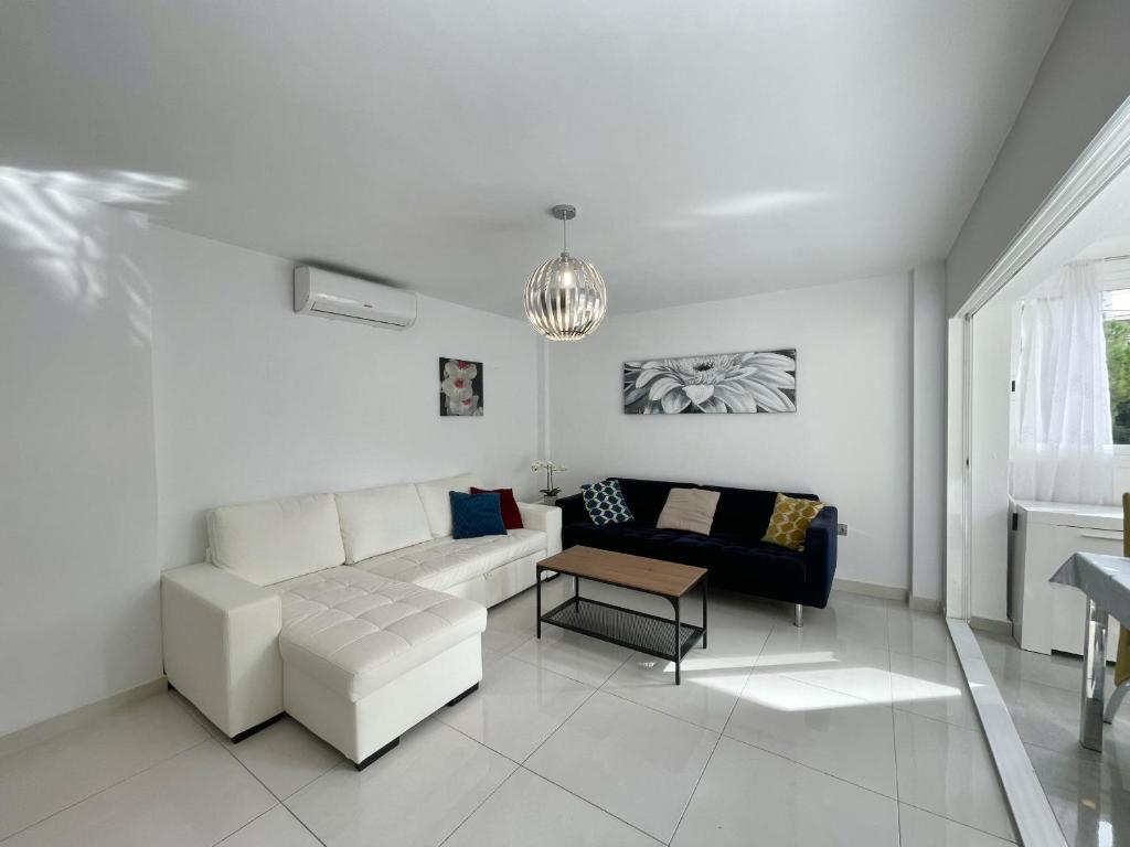 a white living room with a couch and a table at Torre Colon in Benidorm