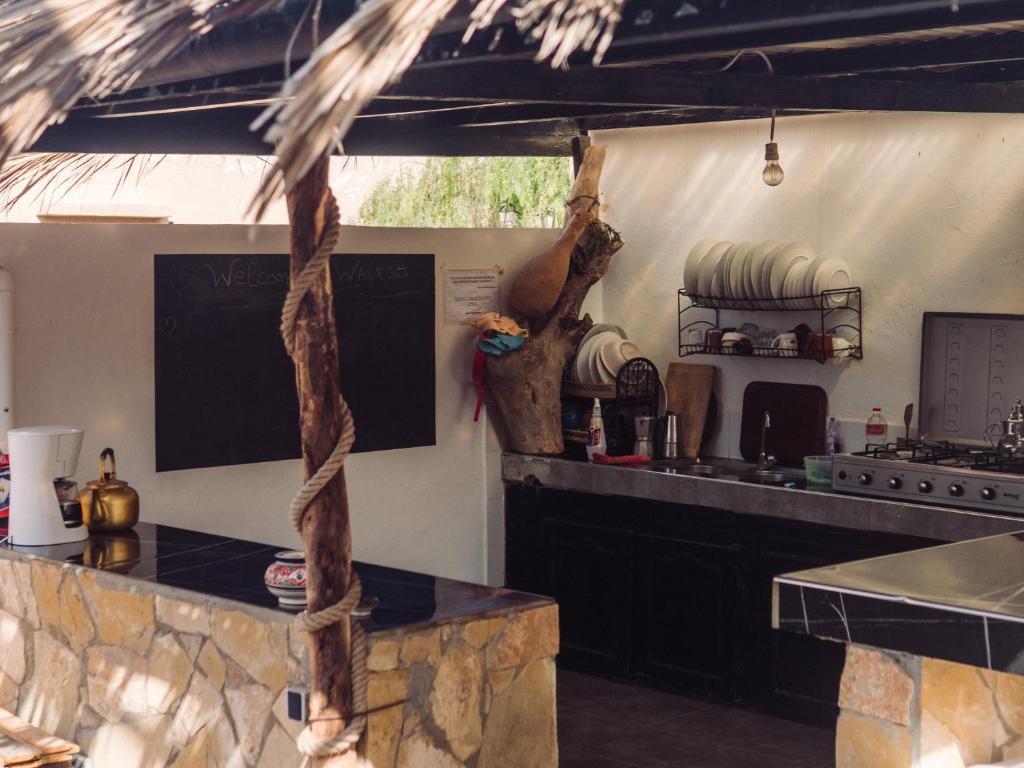 a kitchen with a table and a counter top at WaveGo Surf Camp in Imsouane