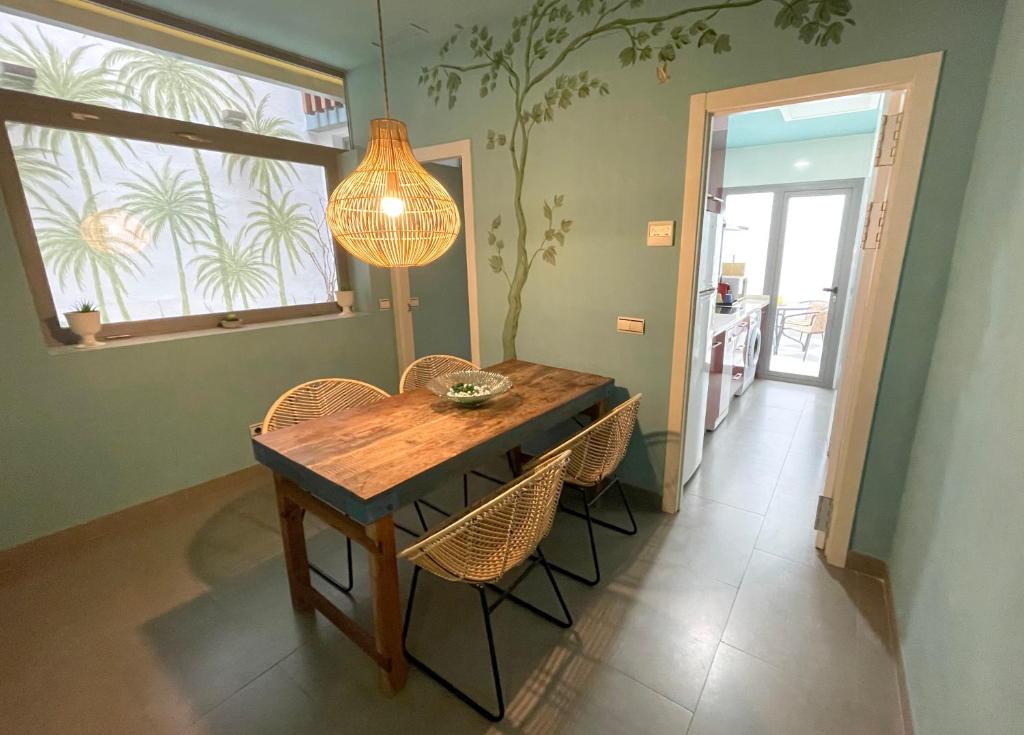 a dining room table with chairs and a chandelier at Ritual Sevilla Suites - Malaver 23 in Seville