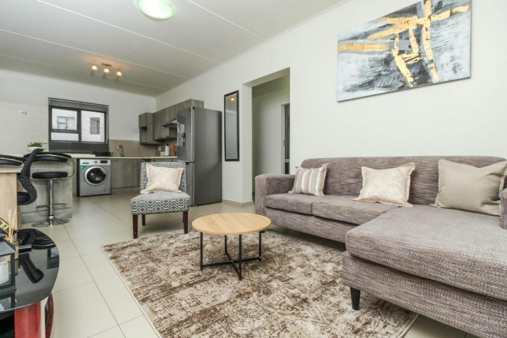 un soggiorno con un divano e un tavolo di The Quintessential getaway a Midrand