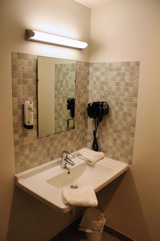 a bathroom with a sink and a mirror at Hôtel Arcadia in Lannion