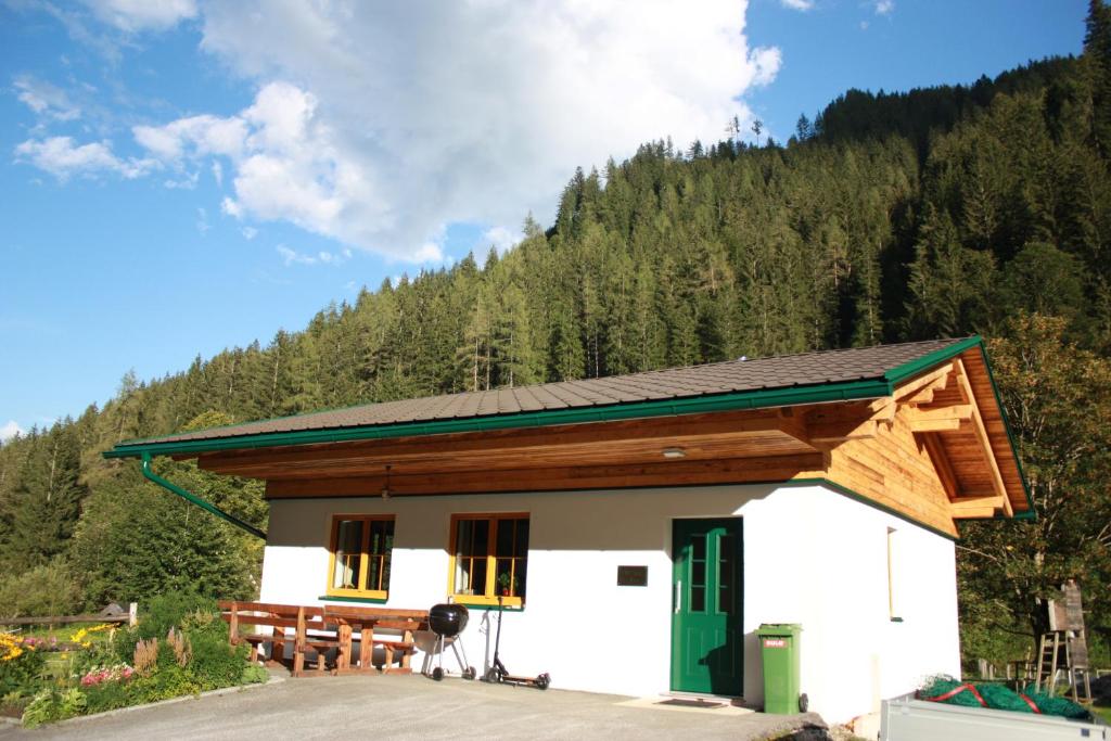 a building with a picnic table in front of a mountain at Chalet Ferienhaus Radmer in Radmer an der Hasel