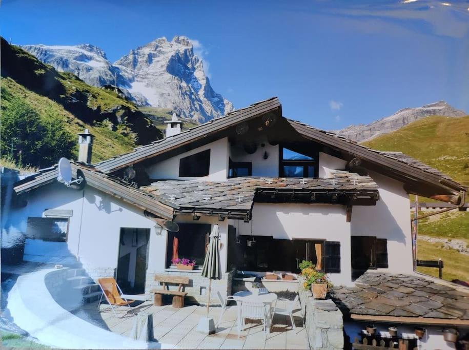 a house in the mountains with a table and chairs at Skichaletcervinia Ski in Ski out 8p op piste nr. 5 uitzicht Matterhorn in Breuil-Cervinia