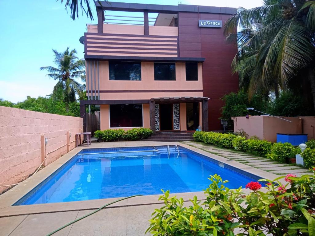 a house with a swimming pool in front of a house at Le Grace Beachview in Chennai