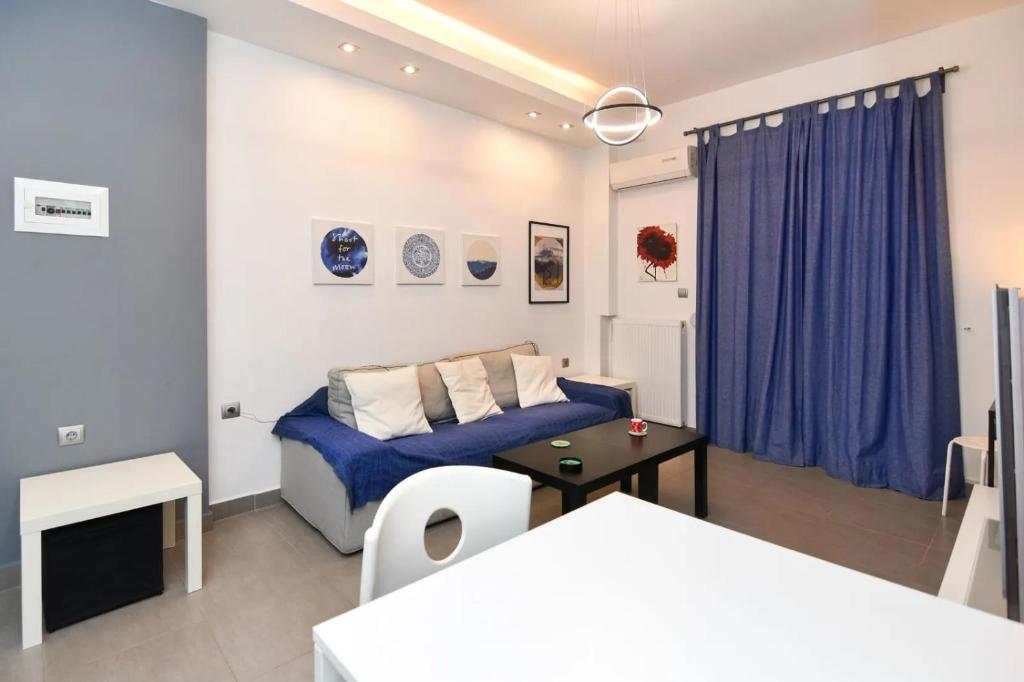 een slaapkamer met een blauw bed en een tafel bij Excellent apartment luxuriously renovated in Larisa