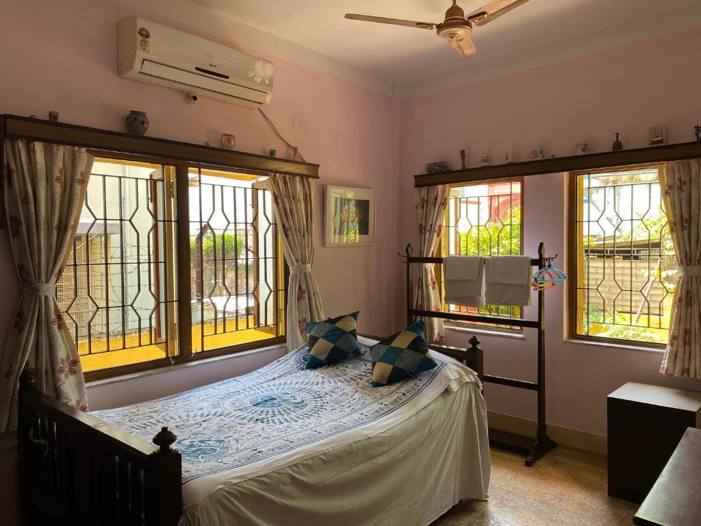 a bedroom with a bed and two windows at Far From The Madding Crowd in Taliganja