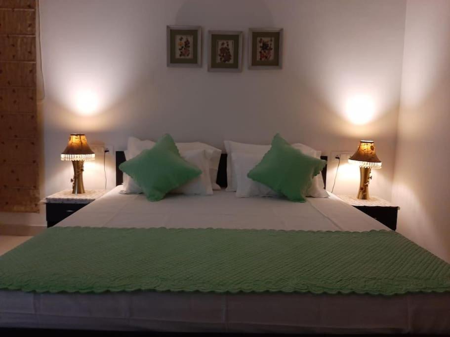 a bedroom with a large bed with green pillows at Colonel's Abbey in Jaipur