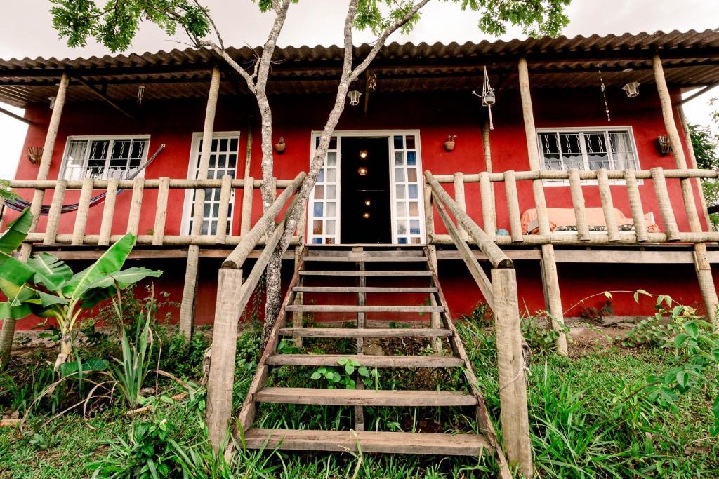a red house with a staircase leading to the front door at Casa confortável, pertinho da cidade e conectada a natureza in Brasília
