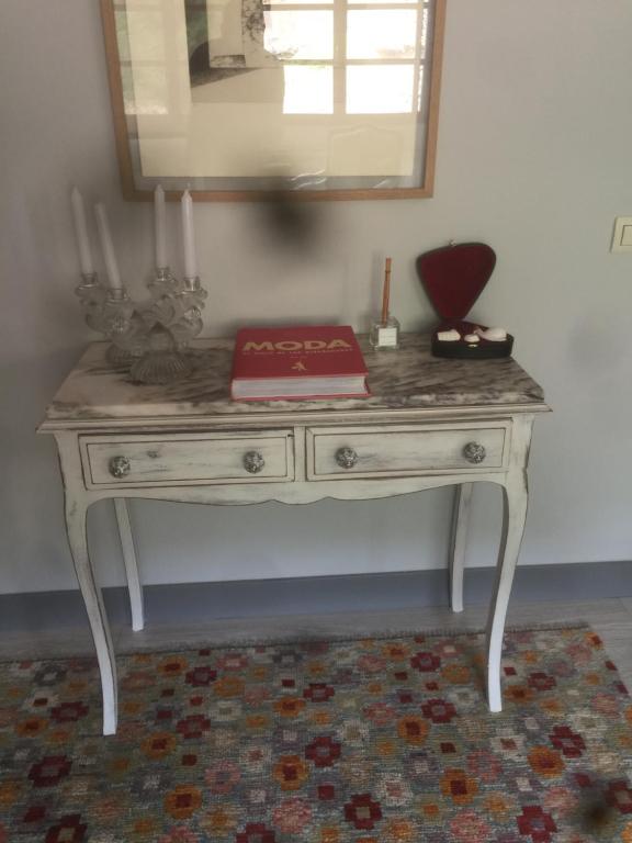 Un escritorio blanco con un espejo encima. en Los acebos, en Gallejones