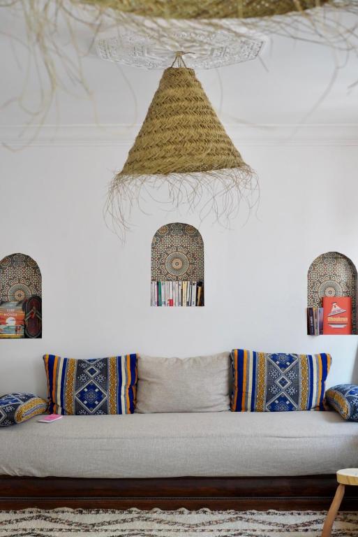 a room with a couch with pillows and a ceiling at Moana Surf Maroc in Tamraght Ouzdar