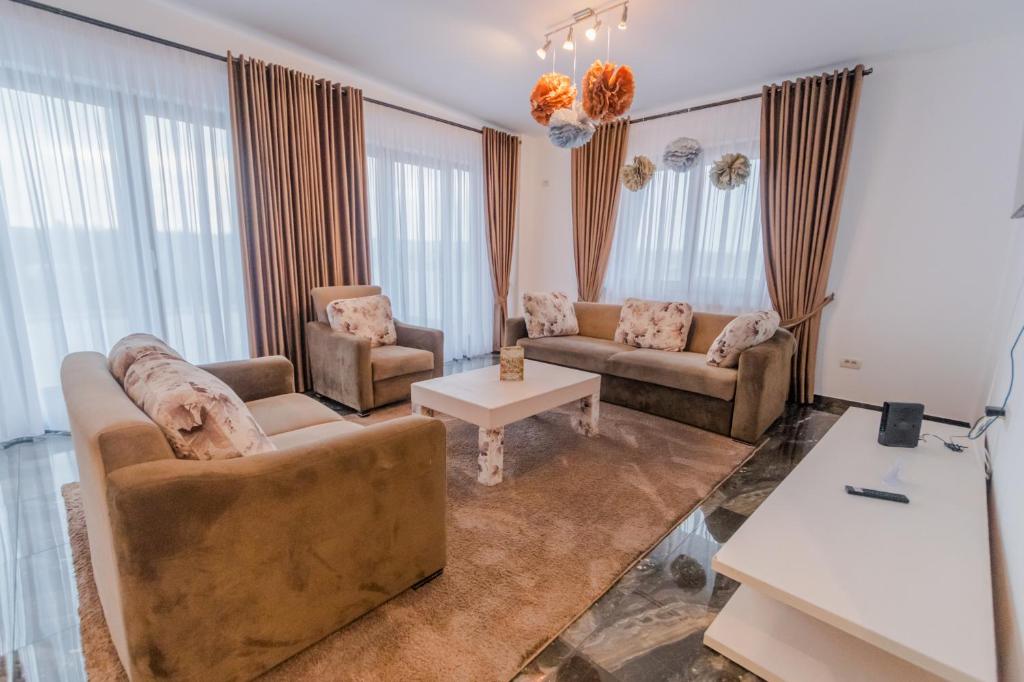 Sala de estar con 2 sofás y mesa en Penthouse Luxury Falticeni, en Fălticeni