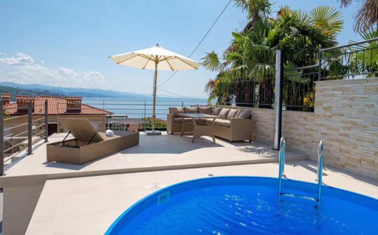 a house with a swimming pool with a view of the ocean at Villa Milla in Opatija