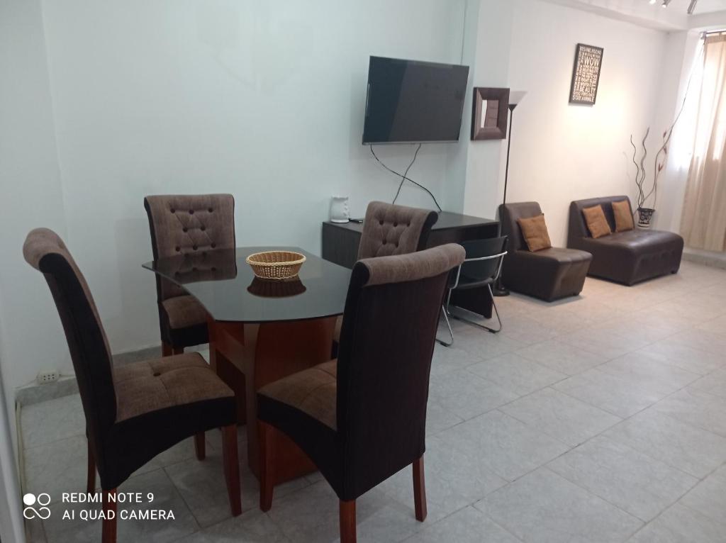 comedor con mesa, sillas y TV en FT Casa Flores Ayacucho 100, en Ayacucho