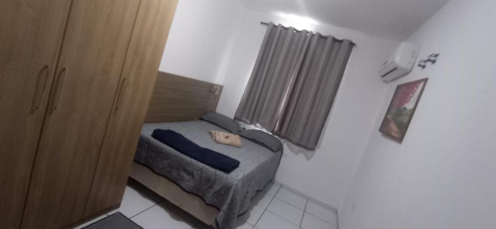 een kleine slaapkamer met een bed en een raam bij Condominio Recanto das palmeiras in Campos dos Goytacazes