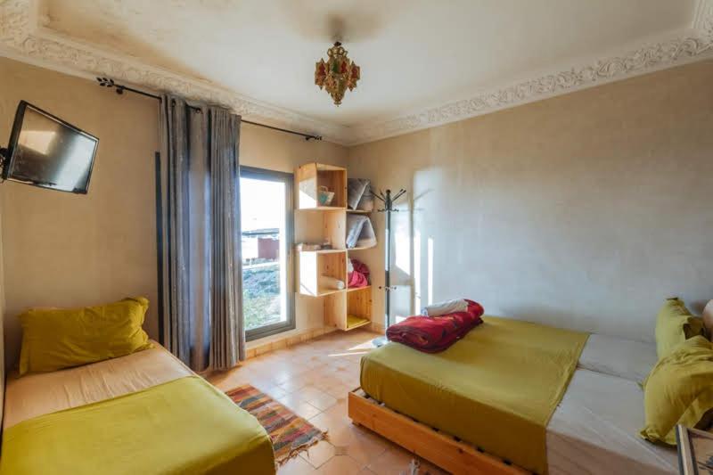 sypialnia z 2 łóżkami i oknem w obiekcie Chillax room for 3P w mieście Imsouane