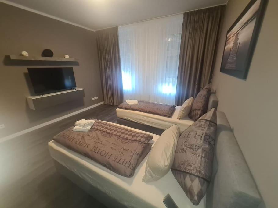 een hotelkamer met 2 bedden en een flatscreen-tv bij Apartament Suite 3 in Bernburg