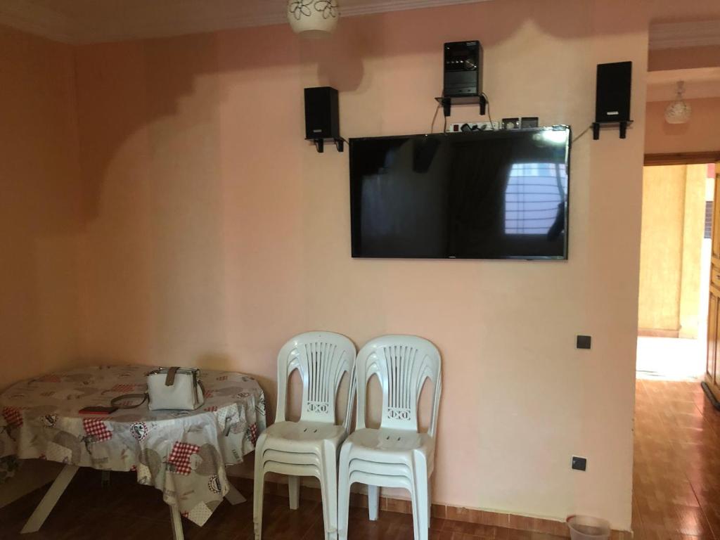 a dining room with two chairs and a table and a tv at Sidi bouzid in Douar Zeraoula