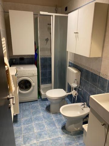łazienka z toaletą i pralką w obiekcie Open Space Torino Centro Storico w Turynie
