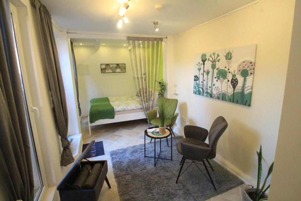 een kamer met een slaapkamer met een bed en stoelen bij Maison No.9 in Rosbach vor der Höhe