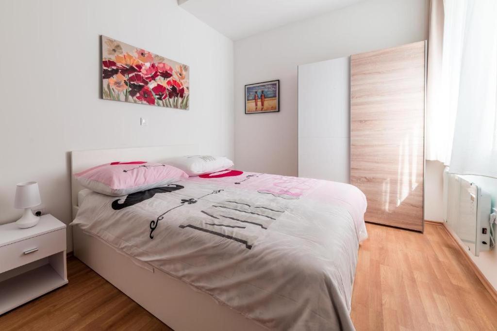 ein Schlafzimmer mit einem großen weißen Bett mit weißer Bettwäsche in der Unterkunft F12 Apartments in Zagreb