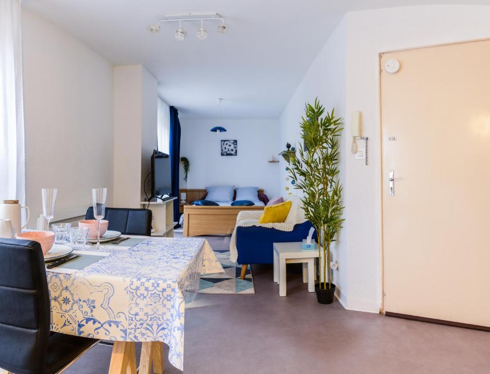 a living room with a table and blue chairs at Studio calme, proche centre, Wifi. in Belfort
