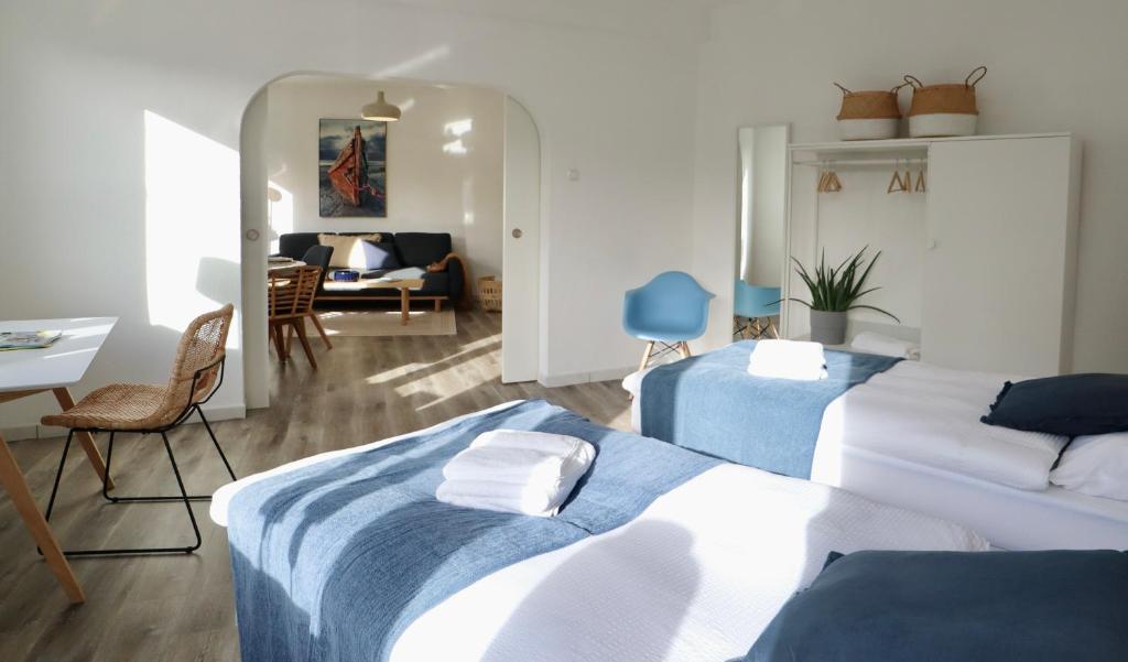 Habitación de hotel con 2 camas y sala de estar. en BOHO APARTMENT: NETFLIX + BALCONY + BATHTUB, en Essen