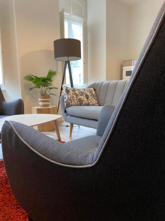 - un salon avec un canapé et une chaise dans l'établissement La Palmeraie - Appartement classé 4 étoiles - Hyper centre ville, à Quimper