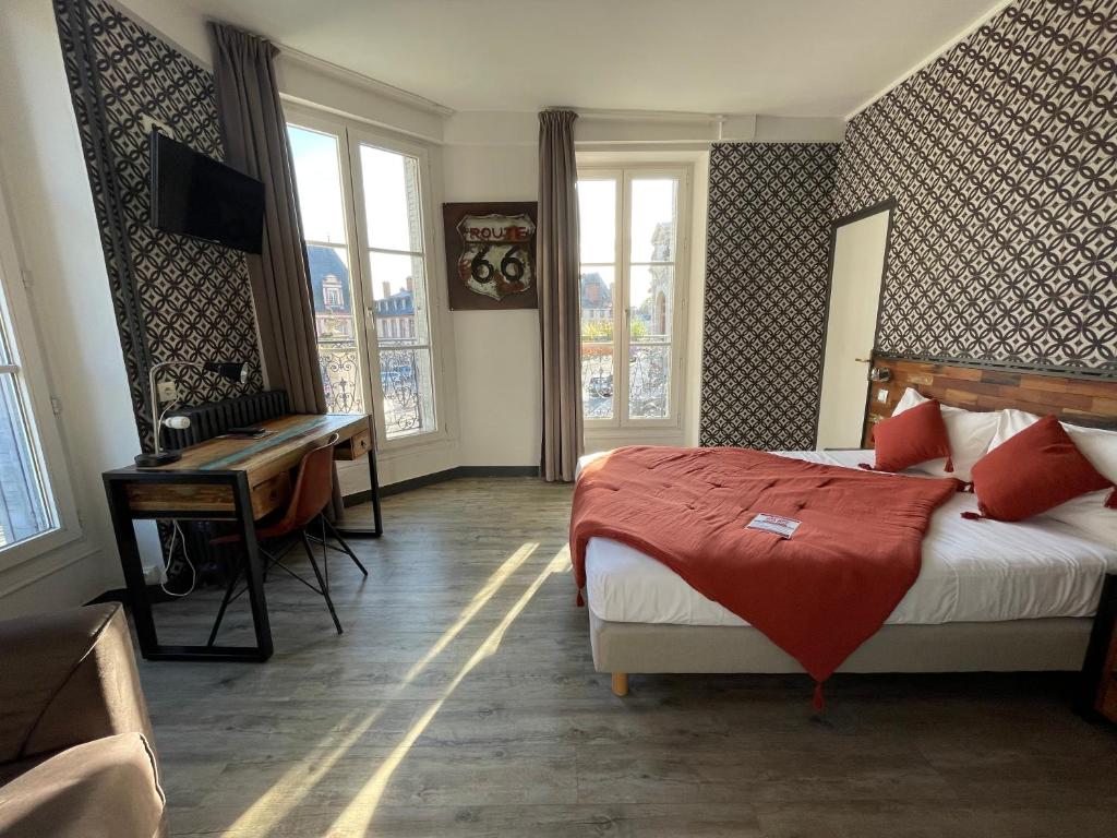 a bedroom with a bed and a desk in a room at Le Richelieu Bacchus in Fontainebleau