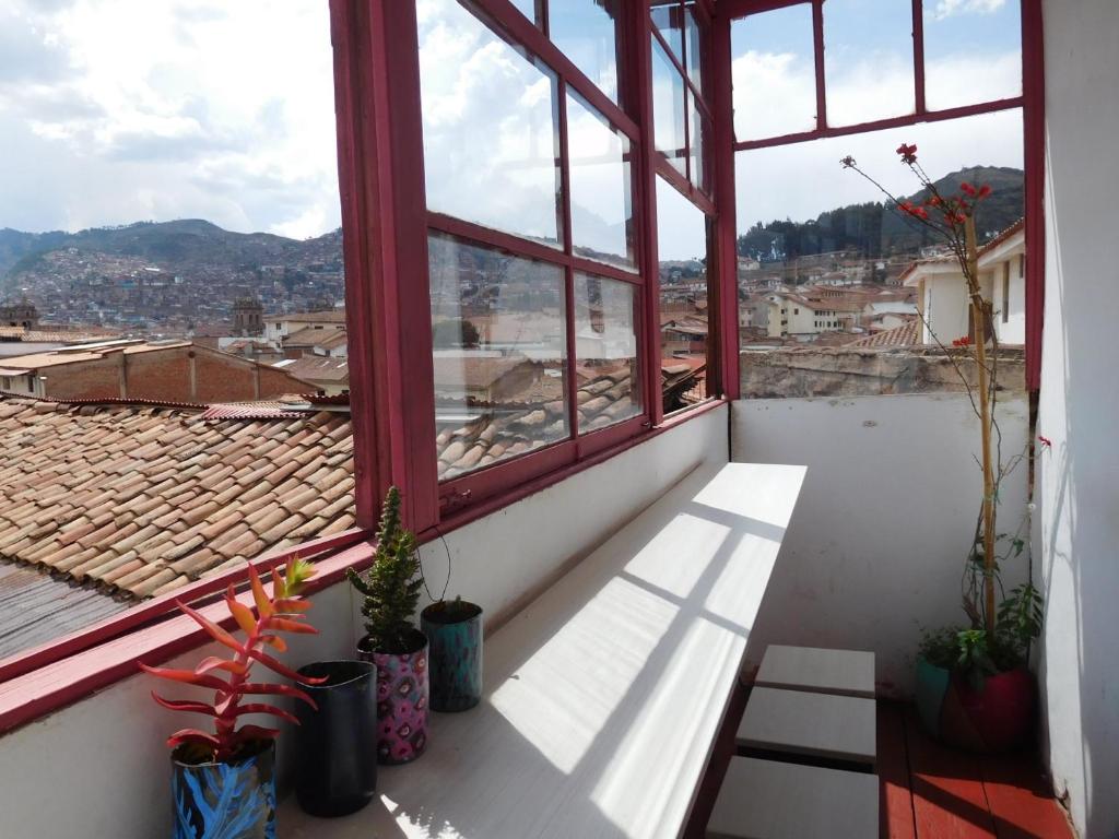 a balcony with a view of a city from a window at MALA HIERBA in Cusco