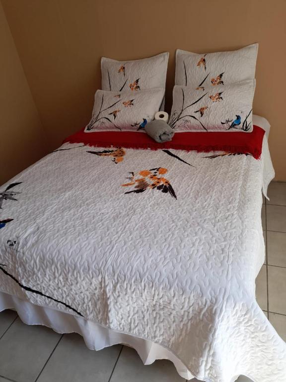 a bed with a white comforter with butterflies on it at Oakfield lounge in Benoni