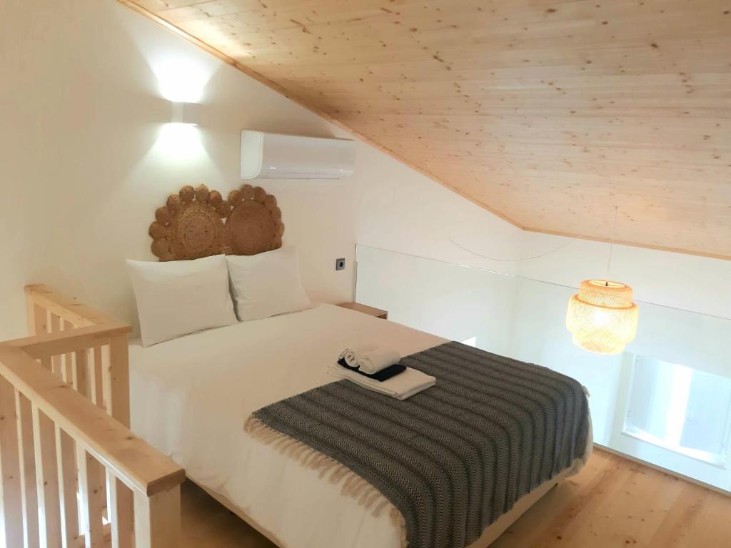 Un dormitorio con una cama con una manta blanca y negra. en Casa aOrta Studios, en Faro