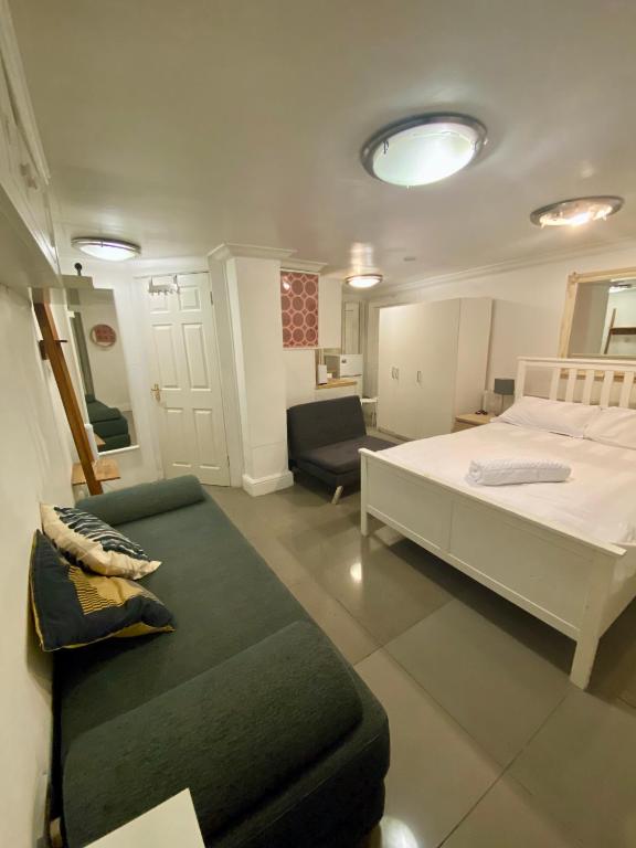1 dormitorio con cama y sofá en Lower ground Bell street, en Londres