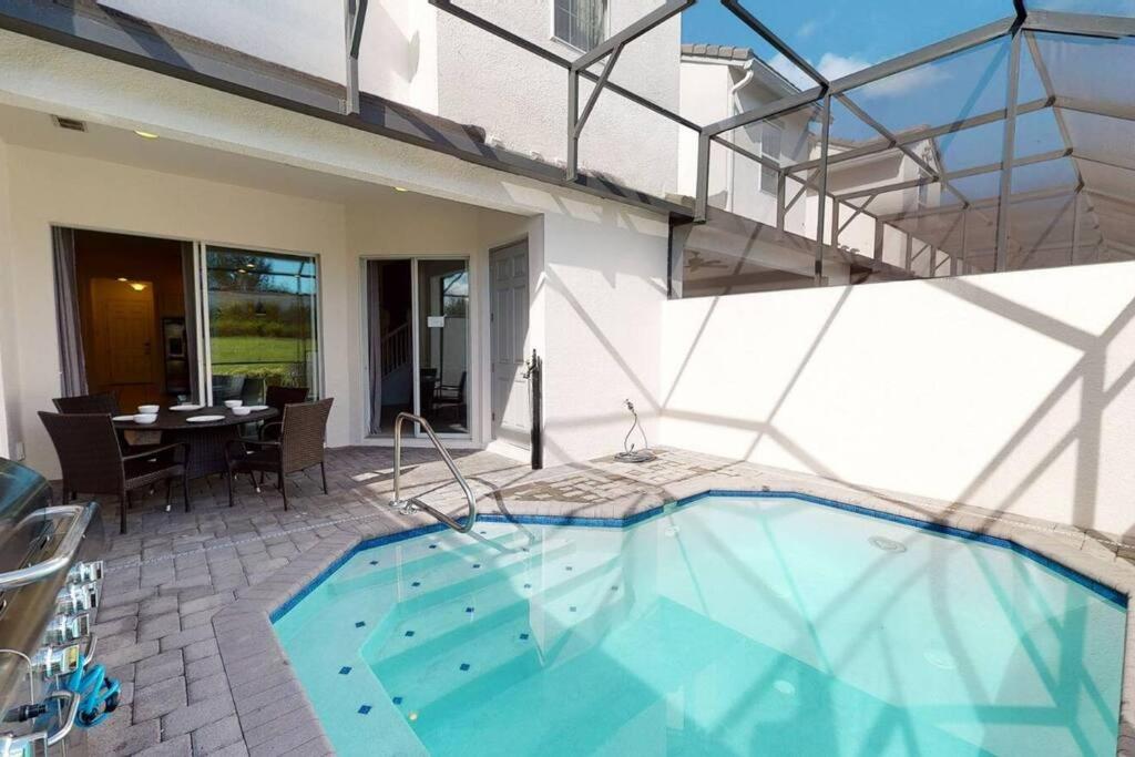 a large swimming pool in a house with a patio at Beautiful townhouse with pool close to Disney in Davenport
