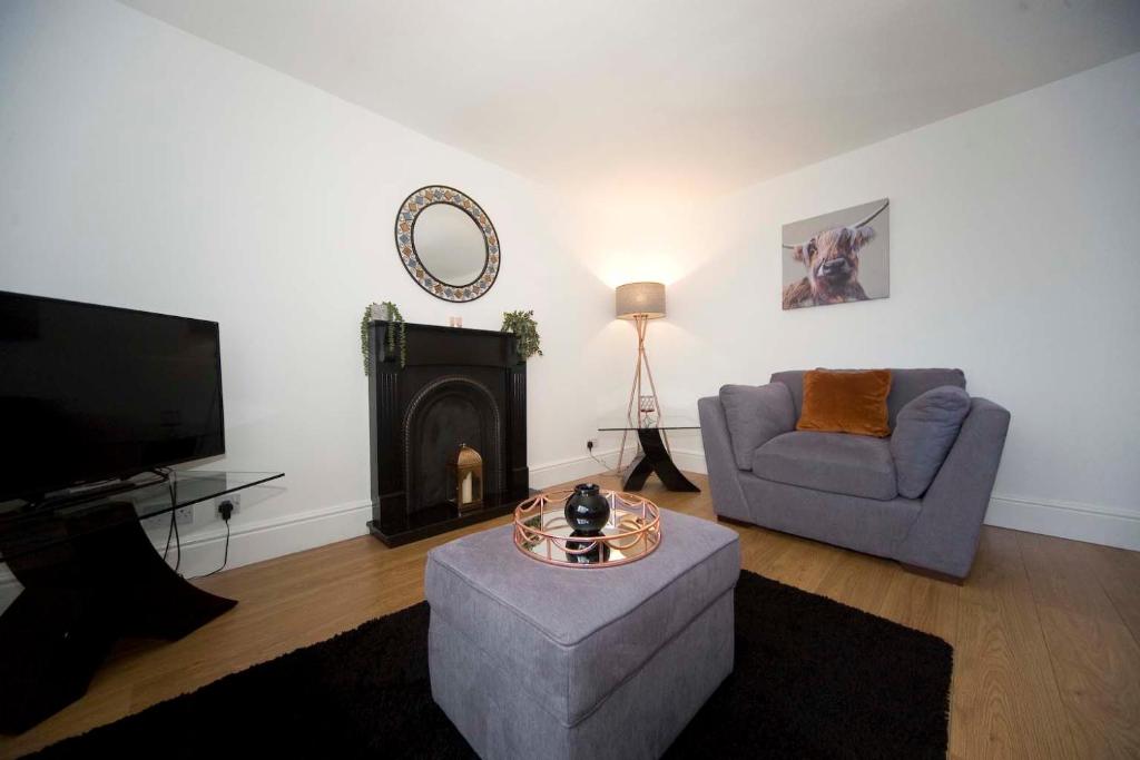 a living room with a couch and a tv at Belmont Budget Apartment in Stockton-on-Tees