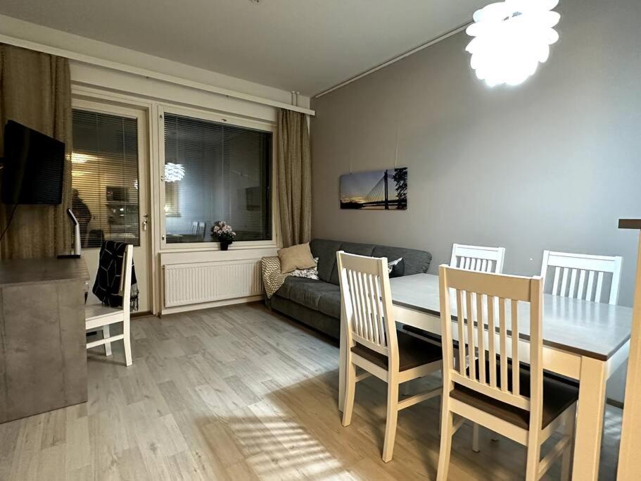 a living room with a table and chairs and a couch at Quality Apt in the City Center For 5 - BRAND NEW in Rovaniemi