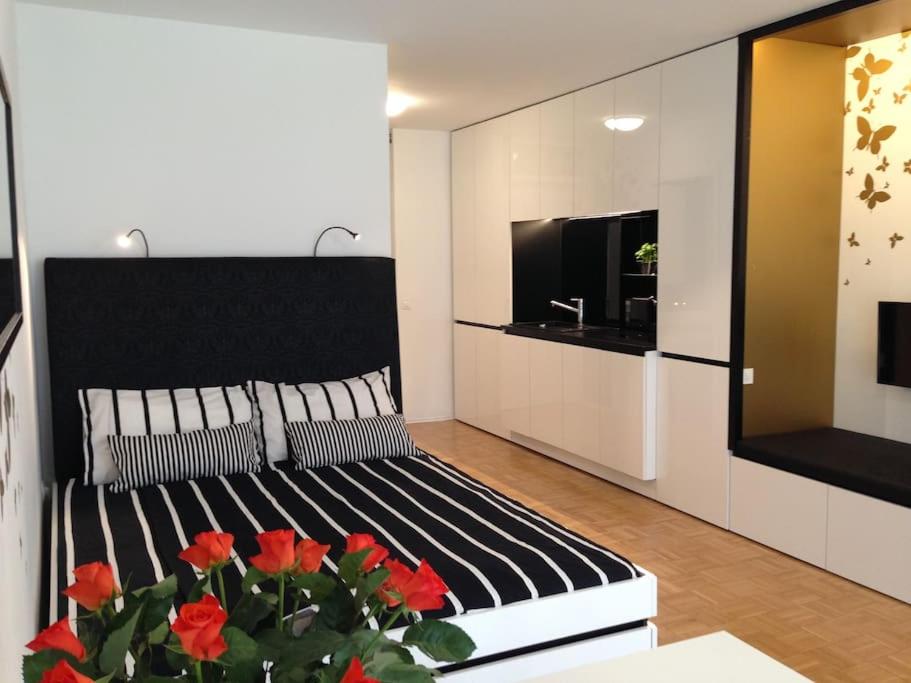 a bedroom with a bed and a tv and red flowers at Gorgeous central flat with garage in Ljubljana