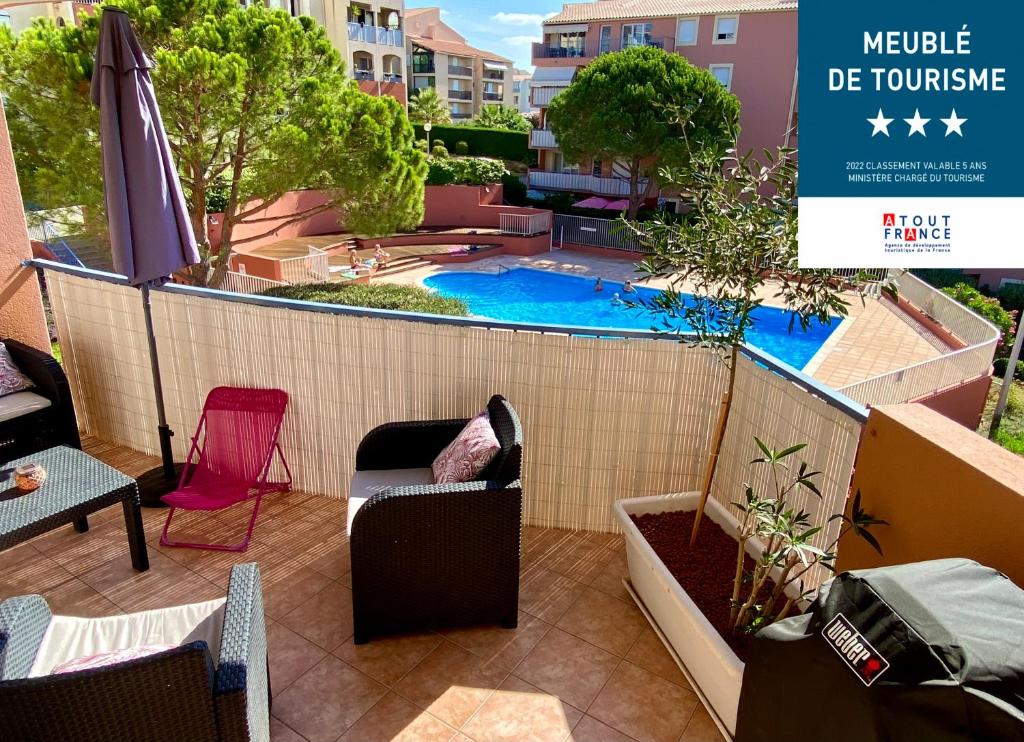 uma varanda com uma piscina num edifício em Coeur de Fréjus, L'AMPHITHÉÂTRE, appartement 3 pièces climatisé, terrasse, barbecue, piscine & parking em Fréjus