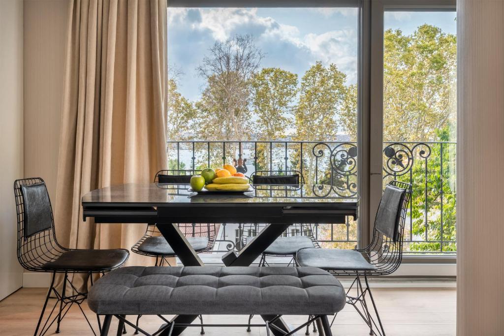 a dining room with a table and chairs and a balcony at Ciragan Bosphorus Apartments in Istanbul